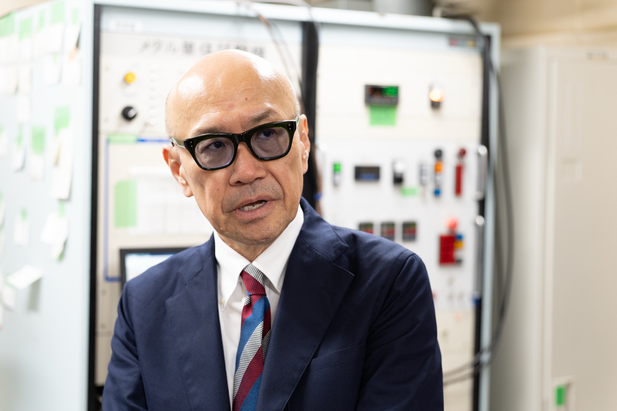 実験室で、研究の説明を行う三原教授。